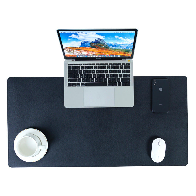 Tapis de bureau noir grand format, présenté avec un ordinateur portable, une souris, un téléphone et une tasse